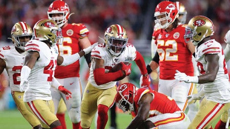 Members of two football teams run on the field